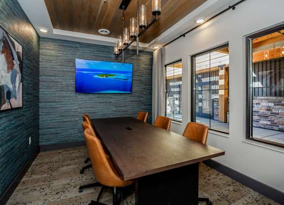 A conference room with a long table and chairs.