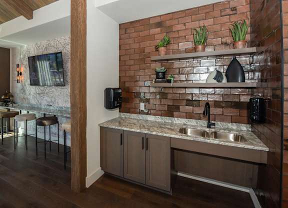 A kitchen with a brick wall and a marble countertop.