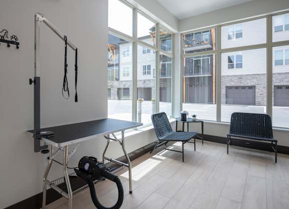 A room with a table, chairs and a vacuum cleaner.