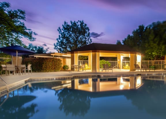 the pool and pavilion of a resort at night