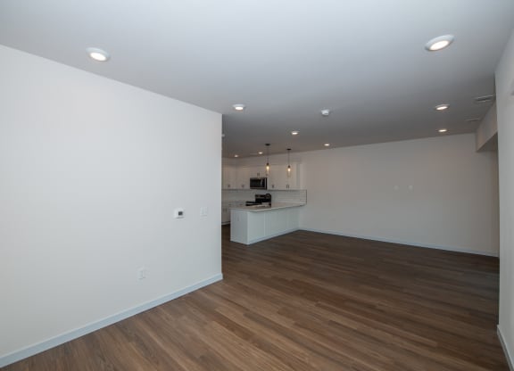 a living room and kitchen with white walls and wood flooring at The Crossings  at Windsong, Prescott Valley