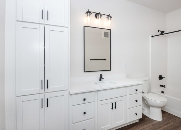 a white bathroom with white cabinets and a white toilet and sink at The Crossings  at Windsong, Arizona, 86314