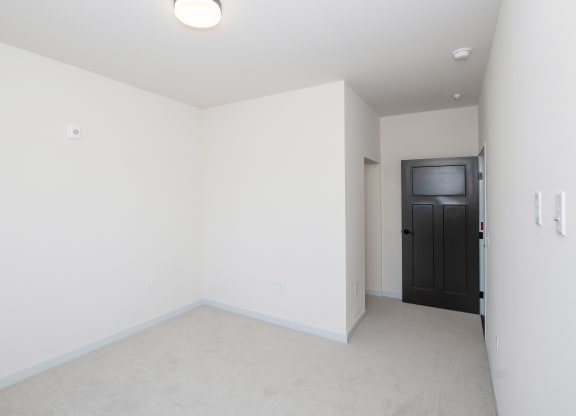 a living room with white walls and a black door at The Crossings  at Windsong, Arizona