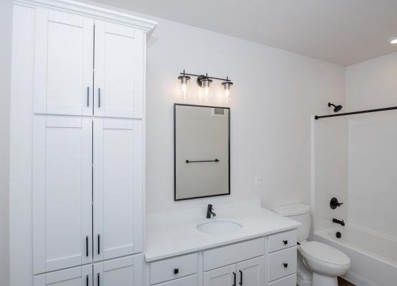 a white bathroom with white cabinets and a white toilet and sink at The Crossings  at Windsong, Prescott Valley, 86314