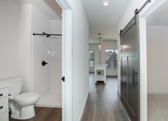 a bathroom with a white toilet and a black shower door at The Crossings  at Windsong, Prescott Valley
