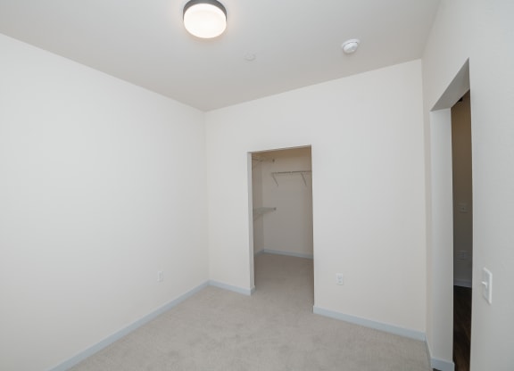 an empty room with white walls and a closet at The Crossings  at Windsong, Prescott Valley, Arizona