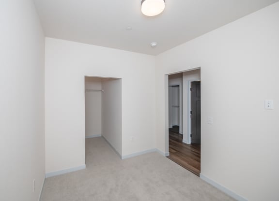 a living room with white walls and a door to a hallway at The Crossings  at Windsong, Arizona