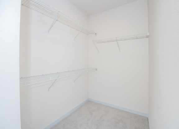 a spacious closet with white walls and shelves and hanging racks at The Crossings  at Windsong, Prescott Valley, Arizona
