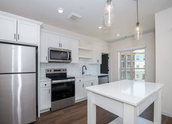 a renovated kitchen with white cabinets and stainless steel appliances at The Crossings  at Windsong, Arizona, 86314