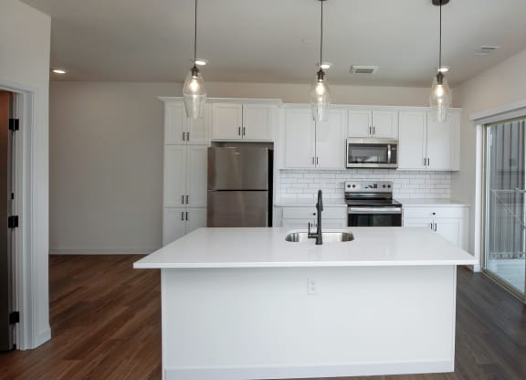 an open kitchen with a large white island and white cabinets at The Crossings  at Windsong, Arizona, 86314