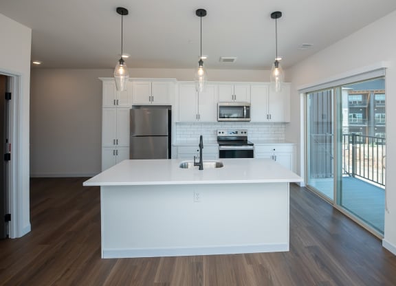 a white kitchen with a large island and stainless steel appliances at The Crossings  at Windsong, Prescott Valley, Arizona