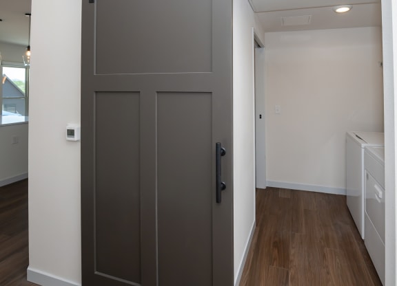 a bedroom with a door and a hallway with a laundry room at The Crossings  at Windsong, Prescott Valley, AZ