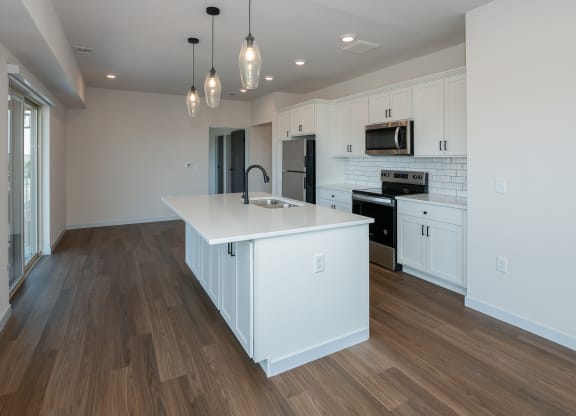a large white kitchen with a large island in the middle at The Crossings  at Windsong, Arizona