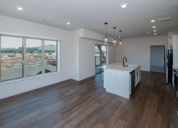a living room with a large window and a kitchen with a island at The Crossings  at Windsong, Prescott Valley