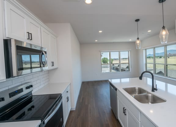a kitchen with white cabinets and black appliances and white counter tops at The Crossings  at Windsong, Prescott Valley, Arizona