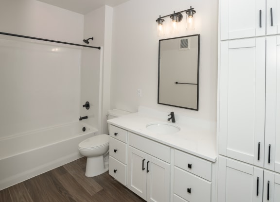 a bathroom with white cabinets and a white toilet and a sink at The Crossings  at Windsong, Prescott Valley, Arizona