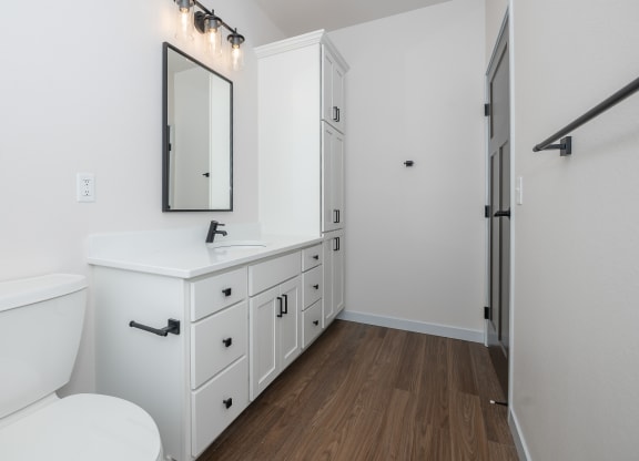 a bathroom with white cabinets and a white toilet and sink at The Crossings  at Windsong, Prescott Valley