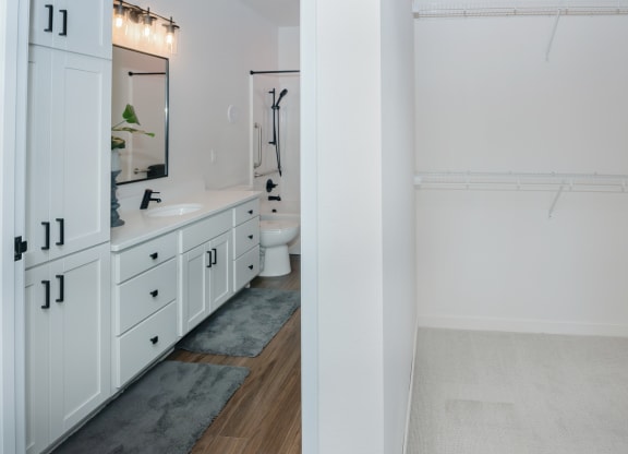 a bathroom with white cabinets and a white sink and a shower at The Crossings  at Windsong, Prescott Valley, 86314