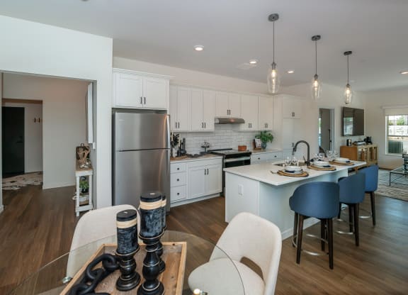 a kitchen and dining room with white cabinets and a stainless steel refrigerator at The Crossings  at Windsong, Arizona, 86314
