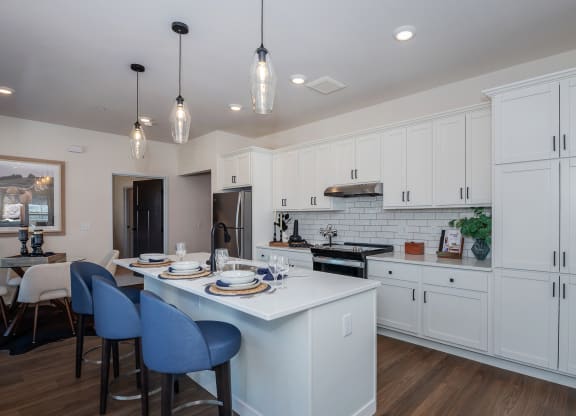 an open kitchen and dining room with white cabinets and a white counter top at The Crossings  at Windsong, Prescott Valley, AZ