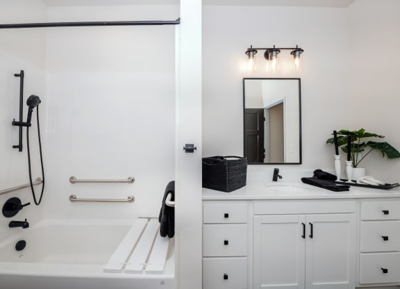 a white bathroom with a tub and a sink and a mirror at The Crossings  at Windsong, Prescott Valley, Arizona