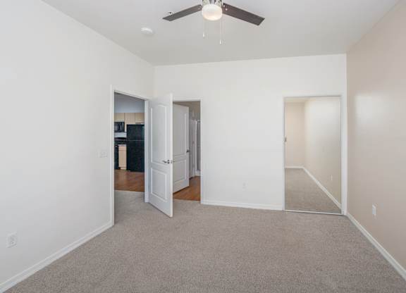 A room with a ceiling fan and carpeted floor.