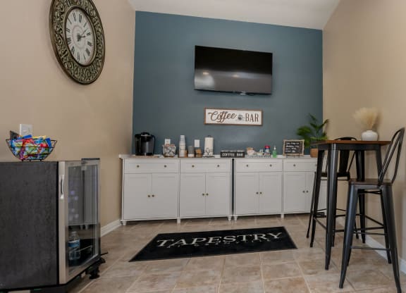 a living room with a bar with chairs and a television