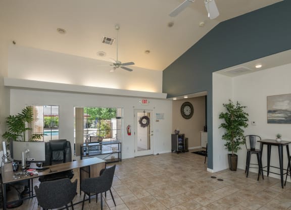 a living room with a table and chairs and a ceiling fan