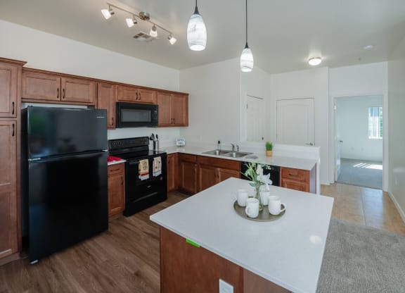 a kitchen with a white counter top and a black refrigerator