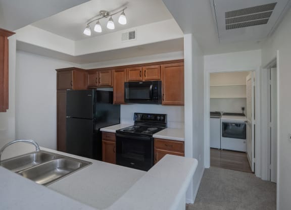 an empty kitchen with black appliances and white counter tops