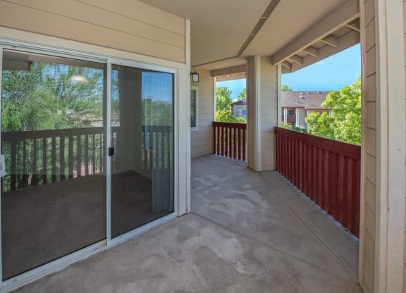 a covered porch with glass doors and a patio