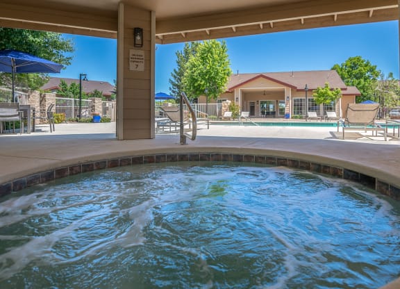 a spa with a pool and a house in the background
