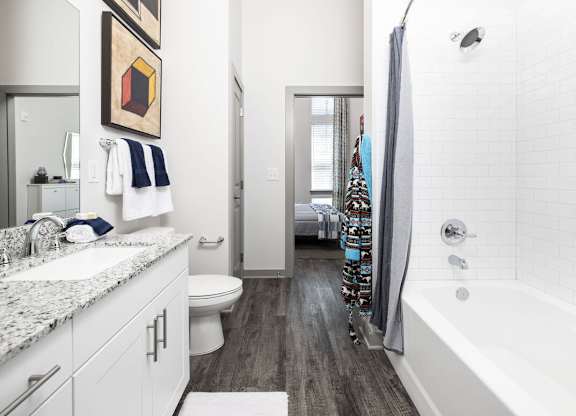 A bathroom with a white tub and a white toilet.