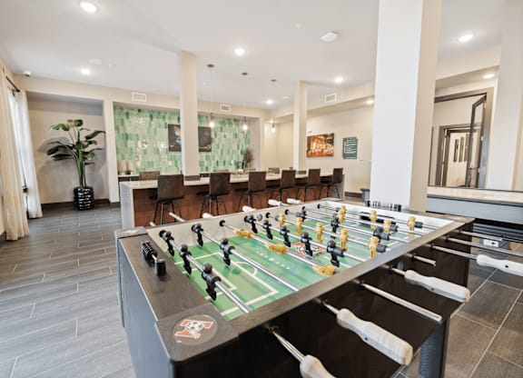 A foosball table in a room with a grey floor and white walls.