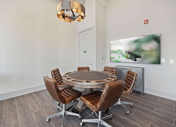 A conference room with a table and chairs and a television screen.