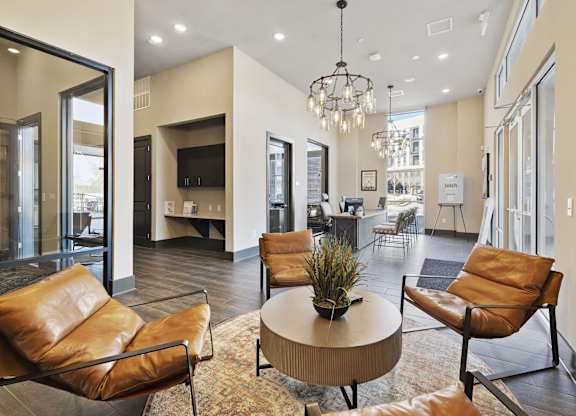 A living room with brown leather chairs and a round table.