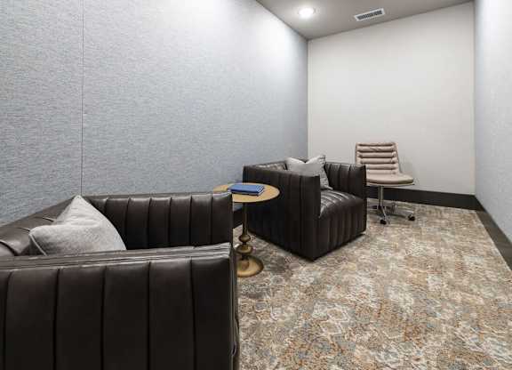 A living room with a brown leather couch and a patterned carpet.