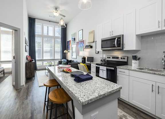 A kitchen with a granite countertop and white cabinets.