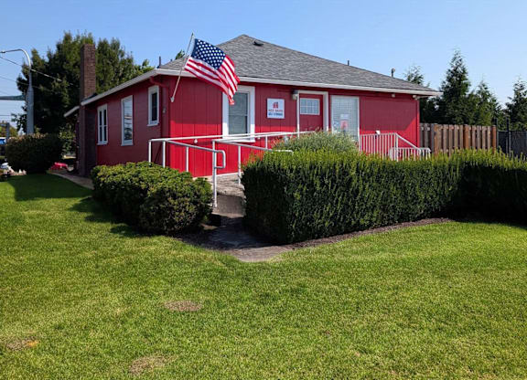 A red house with an American flag on the roof.