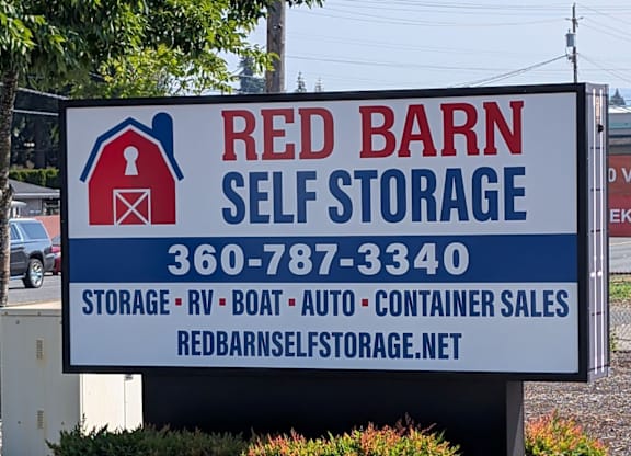 A sign for Red Barn Self Storage with a phone number and website listed.