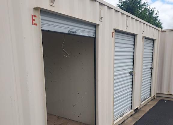 A storage unit with the door open showing a dirty interior.