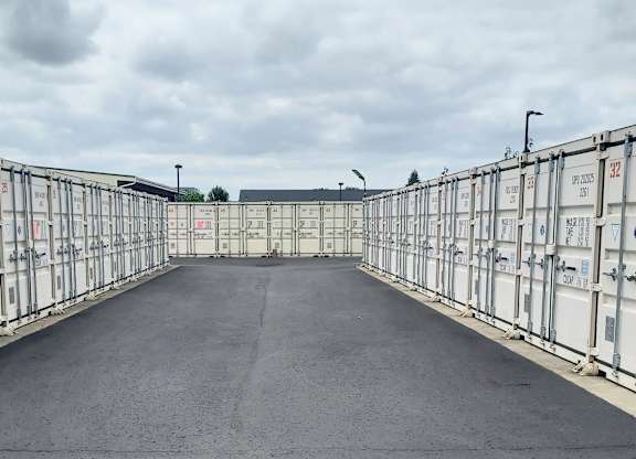 A long corridor with white containers on both sides.
