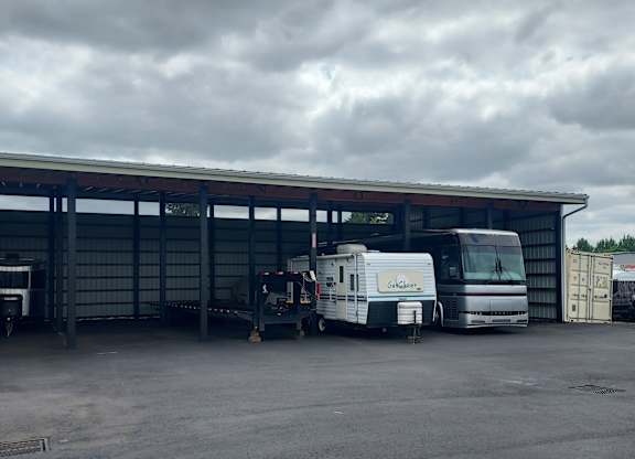 A caravan is parked in front of a large building.