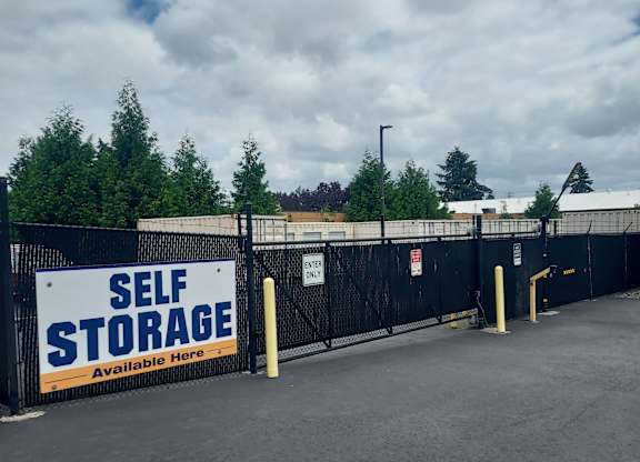 A self storage facility with a sign that says "Self Storage Available Here".