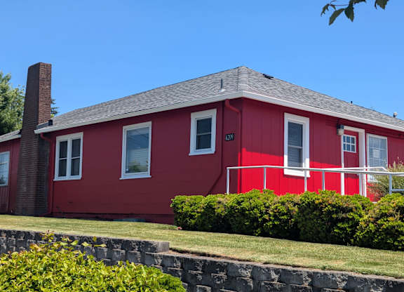 A red house with a stone wall in front.