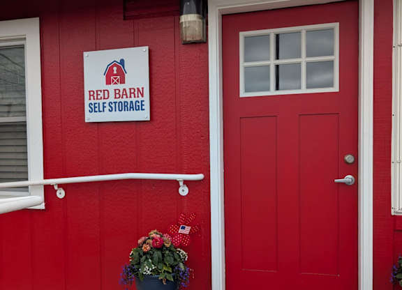 A red barn self storage building with a red door.