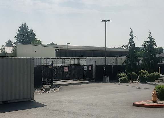 A parking lot with a building and a fire hydrant.