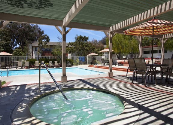 Apartments in Goleta, CA,  for Rent - Pacific Oaks - Poolside Hot Tub Under Pergola with Table, Chairs, and Umbrella.
