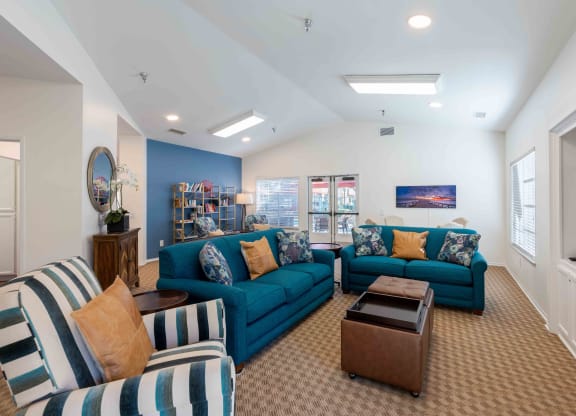 Dog-Friendly Senior Apartments in Ventura, CA - Cypress Meadows - Residential Lounge with High Ceilings, Bookshelves, and Blue Furniture
