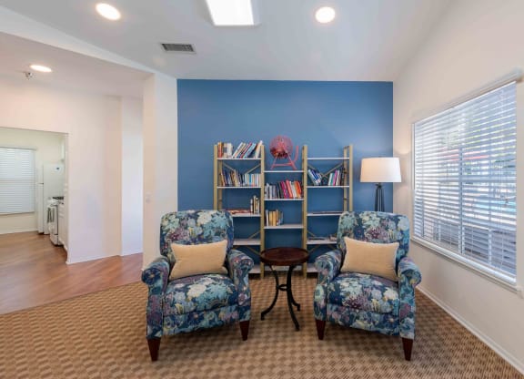 a living room with two chairs and a book shelf
